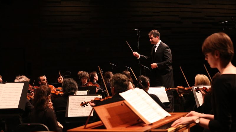Conductor standing over orchestra