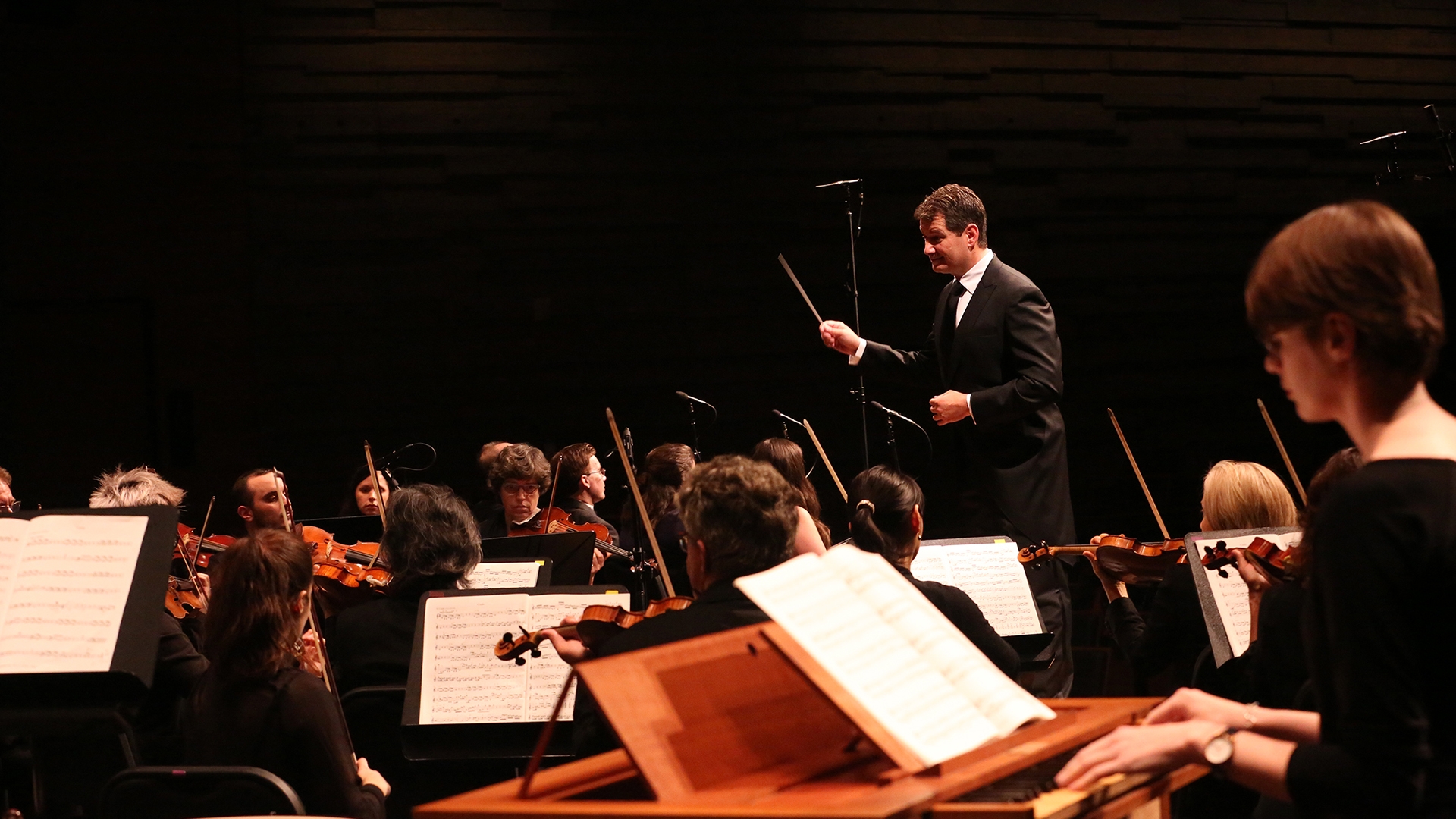 Conductor standing over orchestra