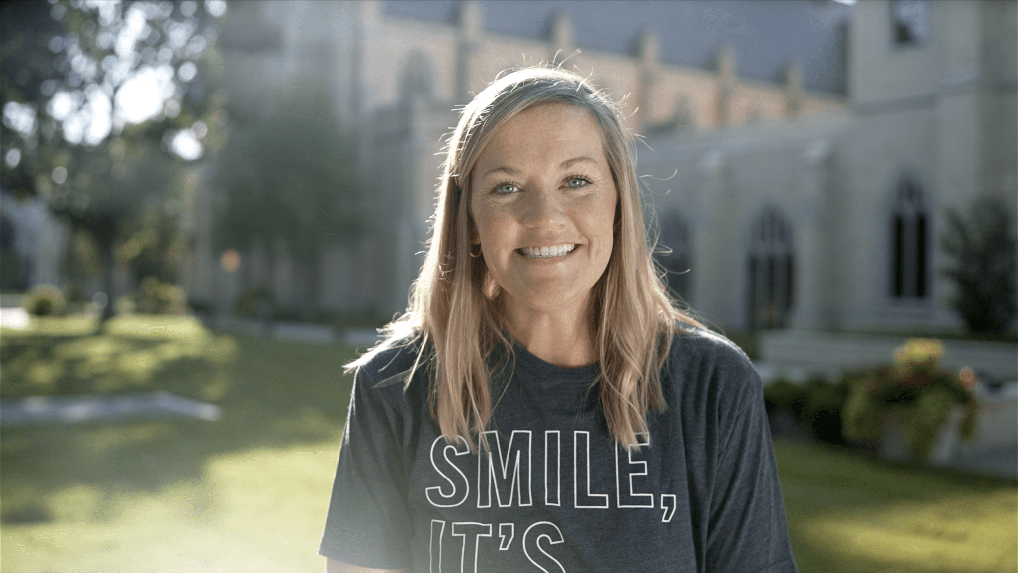 woman smiling at camera in front of church