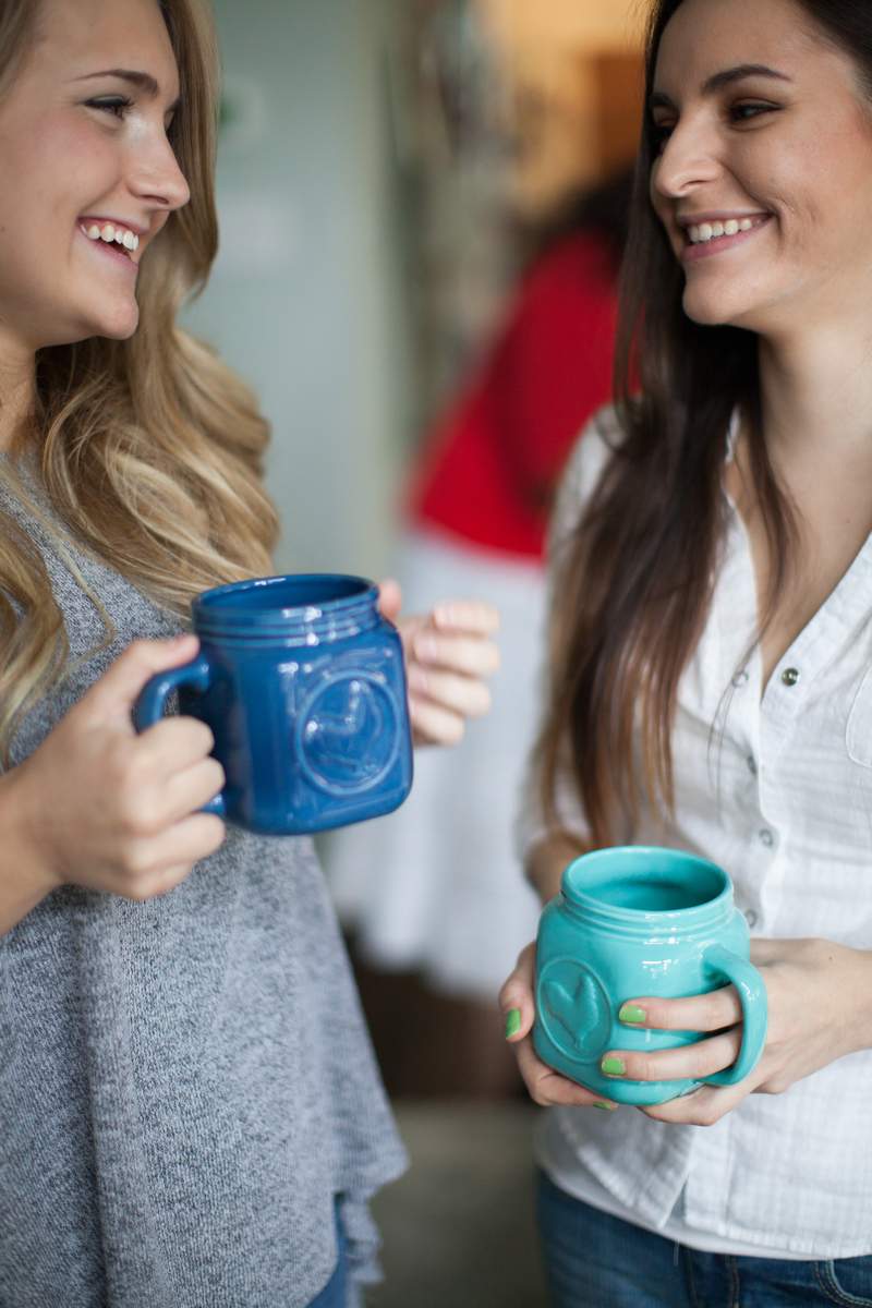 women holding coffee and talking
